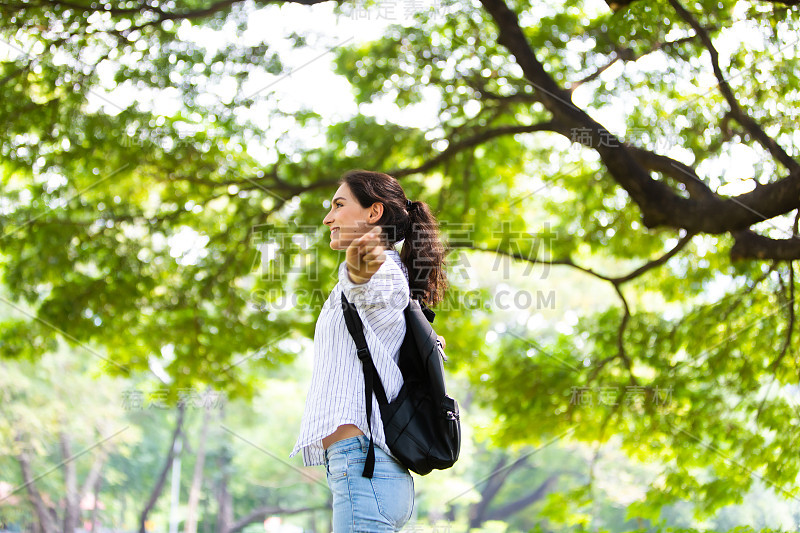 快乐自由的女人在绿色公园享受大自然。Freedome概念。背包旅行的夏天