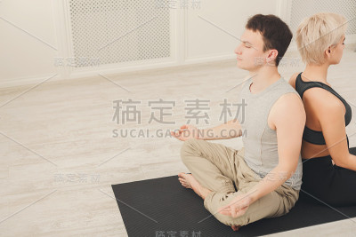 一对年轻情侣在一起冥想，背靠背
