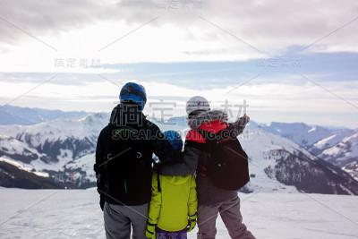 一家人，在阳光明媚的冬日滑雪场滑雪，享受大自然