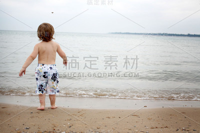 男孩向海滩扔石头
