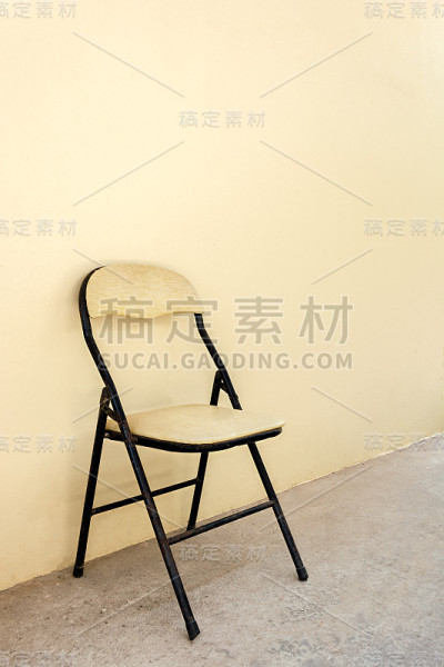 水泥地板上的旧椅子，米色墙壁