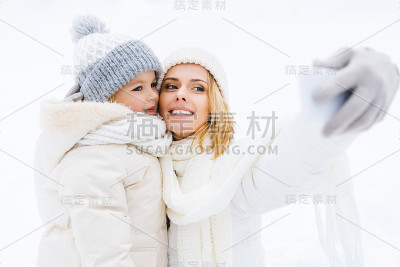 快乐的母女在冬季公园自拍