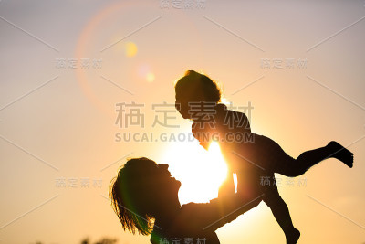 父亲和小女儿在夕阳下玩耍的剪影