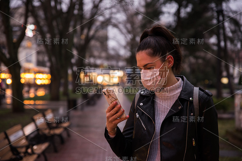 戴着面具的女人黄昏时分在街上打电话