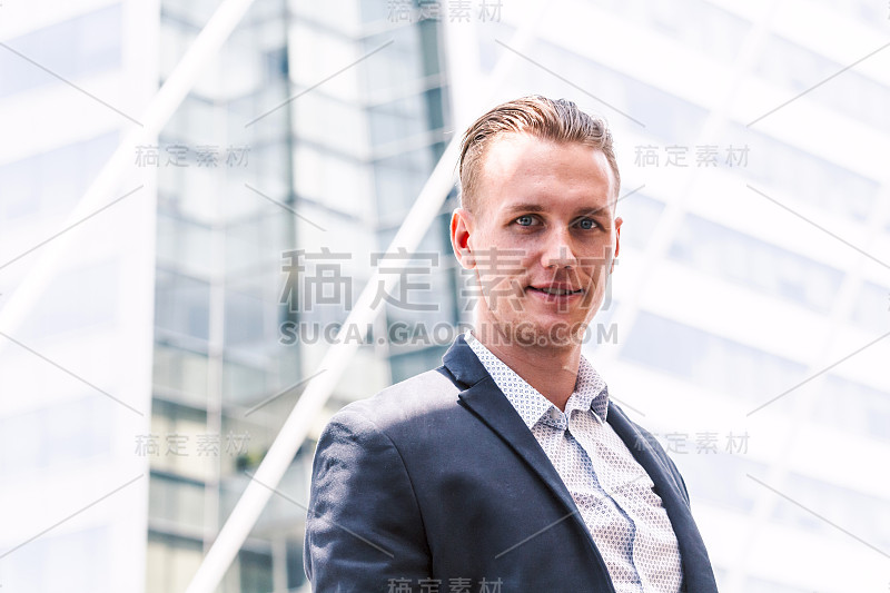 一个穿着黑色西装的英俊男子站在户外的肖像