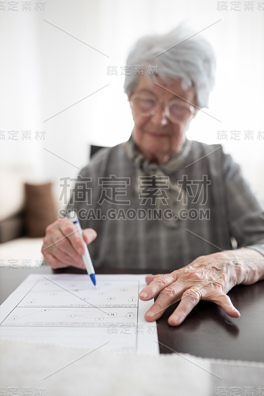 一个严肃的老年妇女的手在做阿尔茨海默氏症或痴呆症自我评估测试的特写