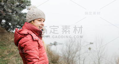 冬天的早晨，一个年轻女子站在河边