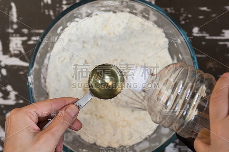 Table spoon with oil in woman hand before putting 