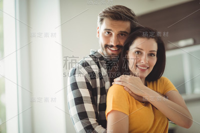 一对幸福的夫妇在厨房拥抱的肖像