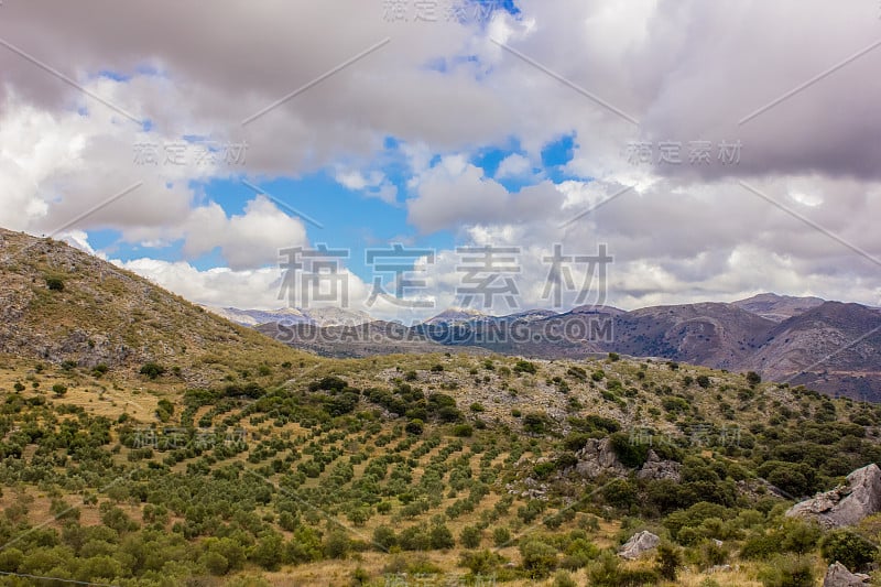 山景上的蓝色多云的天空背景。风景如画的群山在阳光下闪闪发光。令人屏息的自然影像