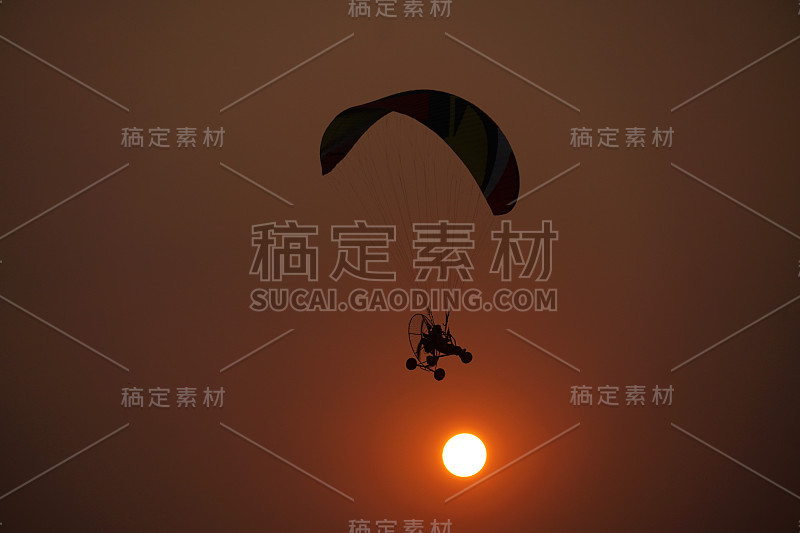 剪影Paramotor秀与日落。