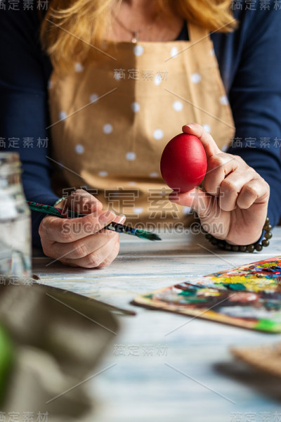 妇女穿着围裙，为传统宗教节日的复活节彩蛋上色