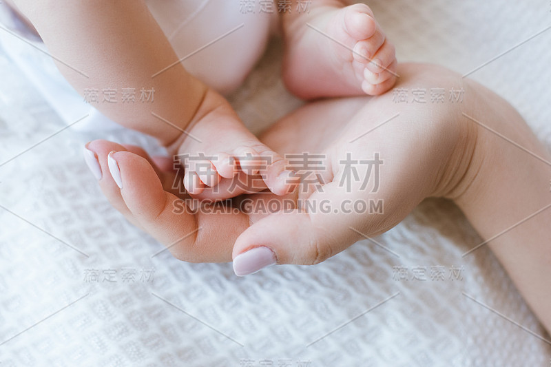 妈妈抱着新生婴儿的腿