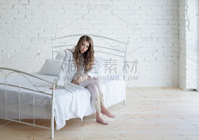 穿着白色内衣躺在白色床上的漂亮女人