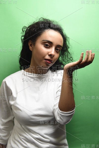 美丽的非洲女孩闻她的香水在绿色的背景