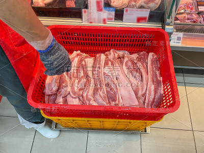 超市员工将生猪肉放入冷藏箱或冰箱