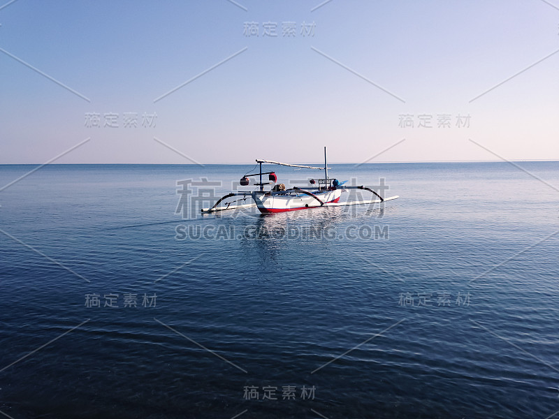 海滩上平静的海水和村庄里传统的渔船景色