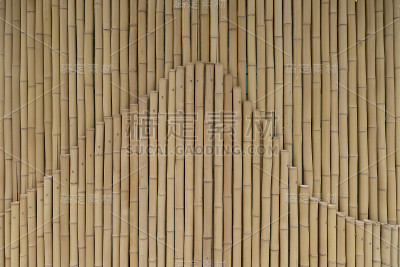 黄竹竿排成两行。篱笆用木头做成的篱笆或篱笆为背景设计纹理，文本复制空间的位置