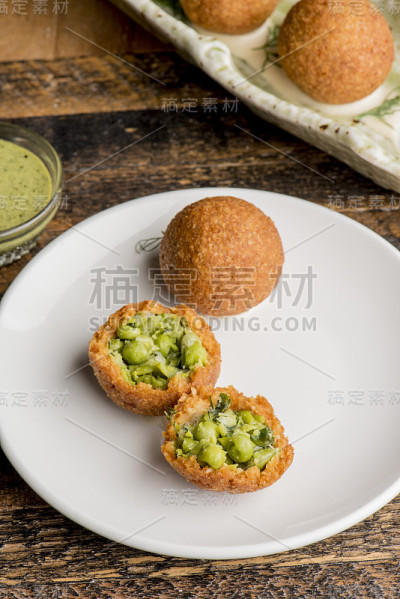 炸丸子或炸丸子。汤圆里塞满了酱汁和豌豆，是最受喜爱的西西里小吃和街头小吃之一。馅料为肉ragù，青豆