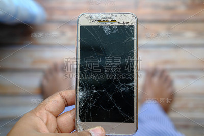 俯视图的人手持损坏智能手机