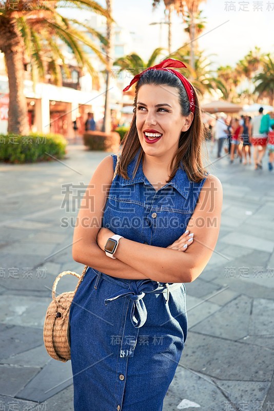 一个阳光明媚的夏日，年轻美丽的女人快乐地走在特内里费港的德拉克鲁兹市的街道上