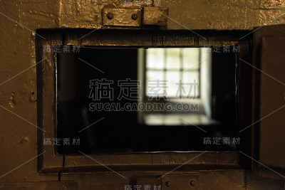 透过监狱门上的小窗，可以看到黑暗的牢房
