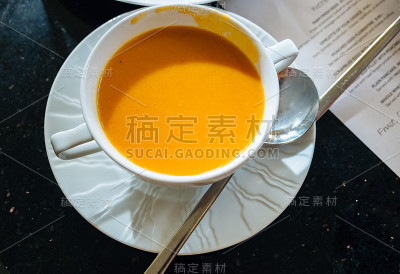 西红柿汤在白色的杯子里用勺子