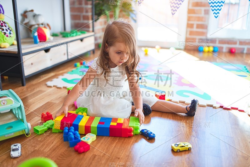 可爱的金发小孩在幼儿园玩很多玩具