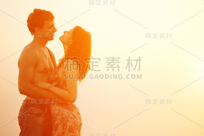 年轻情侣在海滩上拥抱亲吻