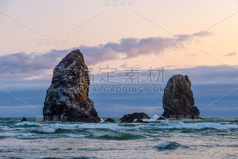 岩石超过鸟岛附近的干草堆岩石在黄昏或日落，坎农海滩，俄勒冈海岸风景，美国公路101，或，美国。