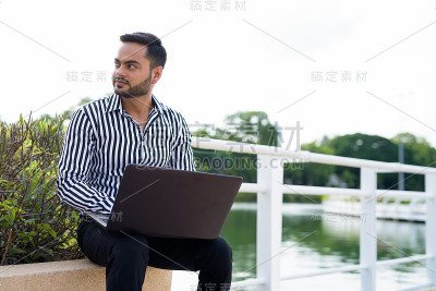 年轻的印度商人在公园休息的肖像