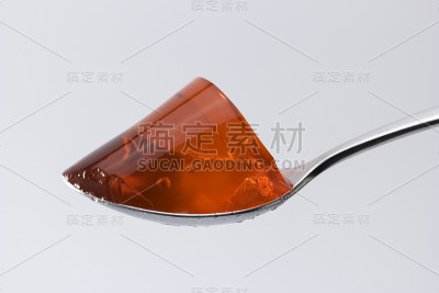 一勺白色背景的草莓味果冻