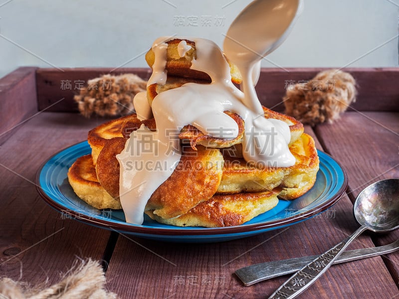 自制的新鲜早餐，热煎饼配酸奶油放在蓝色陶瓷盘子里