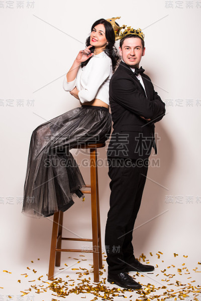 优雅的年轻男女坐在戴着皇冠的椅子上