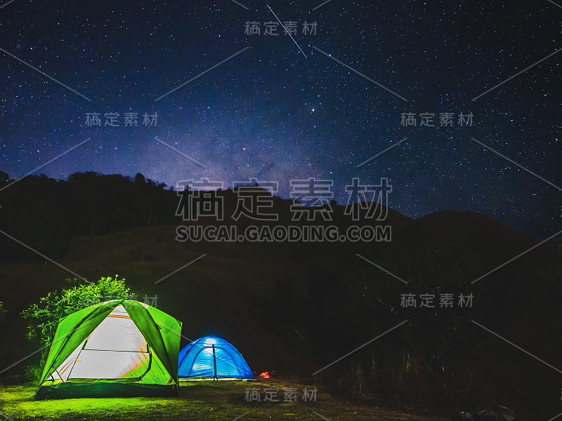 夜晚露营概念从帐篷在星空下的山与星星和银河。