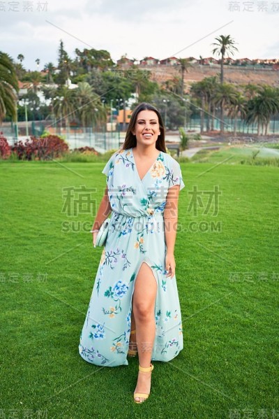 年轻美丽和优雅的女人与婚礼的客人服装微笑快乐和愉快