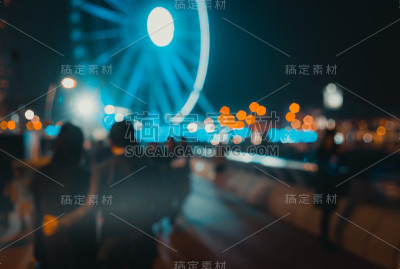 摘要散景背景下的人们在夜晚的滨水上行走