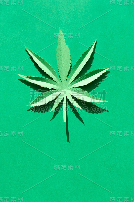 在绿色背景上用纸制成的大麻叶子