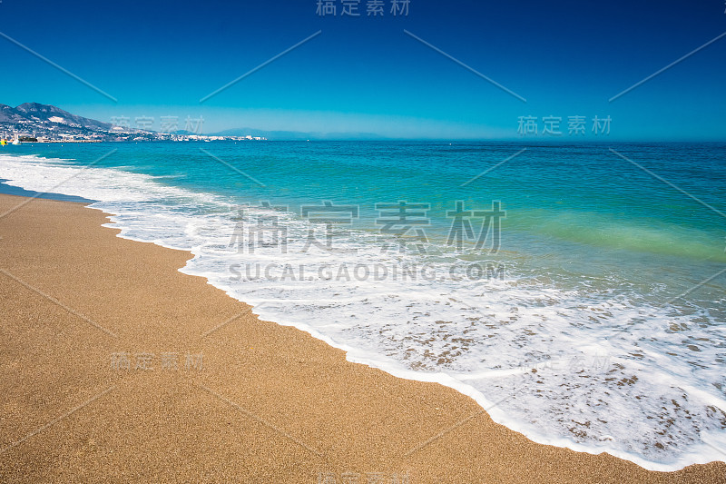 柔软的海洋海浪冲刷金色的沙子背景