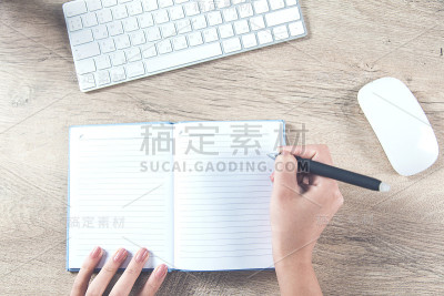 女人手里拿着笔记本和键盘