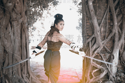漂亮的亚洲女人在泰国古代武士服装摆姿势。