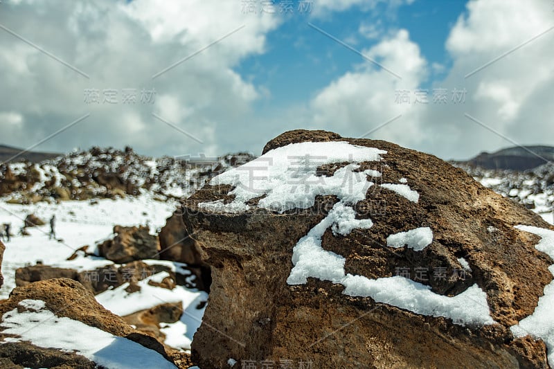 泰德火山的基地。熔岩谷有白色的雪点，部分被美丽的云覆盖。明亮的蓝色天空。泰德国家公园，特内里费，加那