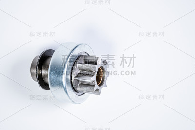 新备件-灰色背景下电机起动器的起动齿轮传动。经典的齿轮传动通过扭矩传动