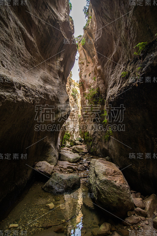 塞浦路斯的阿瓦卡斯峡谷。小河流在前景，阳光照射的岩石在背景