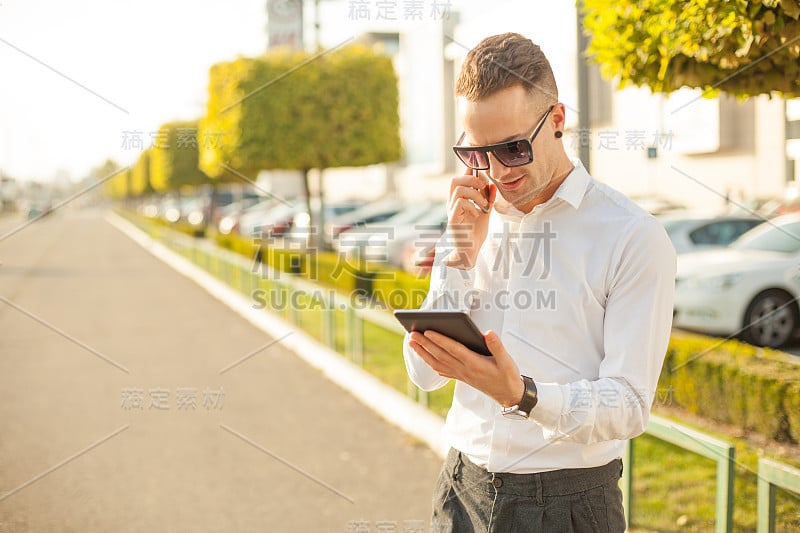 手持手机和平板电脑的商人