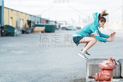 女子在工业城区做跳高