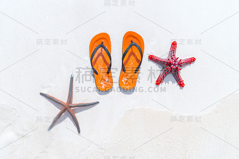 白色沙滩上有拖鞋和海星。