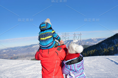 爸爸、妈妈和孩子们在雪地里散步，玩得很开心。