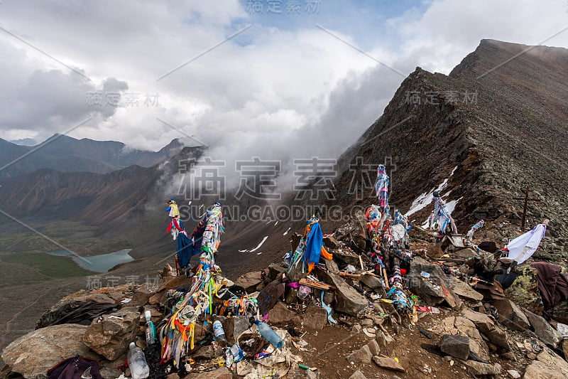 许多象征性的丝带系在山口上。乌云笼罩着山脉。下面山谷里的湖。水平的。