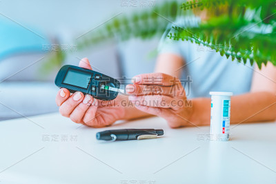 男性手指的闭合带血滴和测试条纹